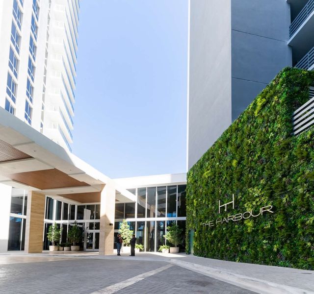 Outdoor Artificial Vertical Green Wall design in Hotel and Condominium entrance hides parking structure and side of building with vertical garden