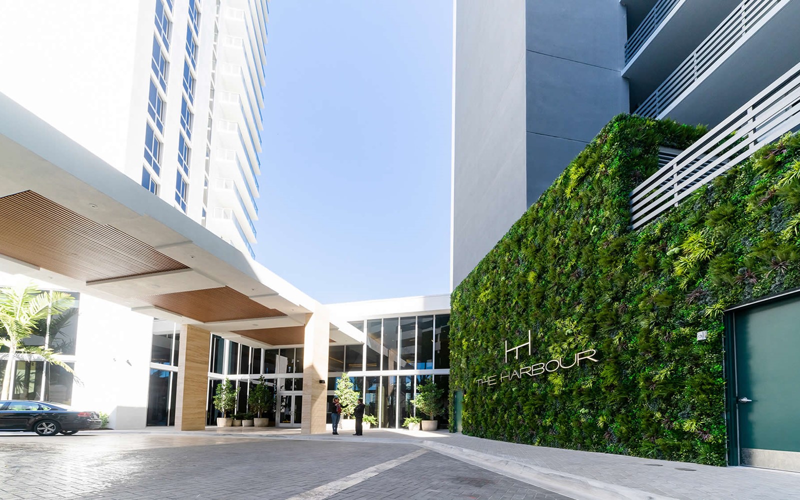 Outdoor Artificial Vertical Green Wall design in Hotel and Condominium entrance hides parking structure and side of building with vertical garden 